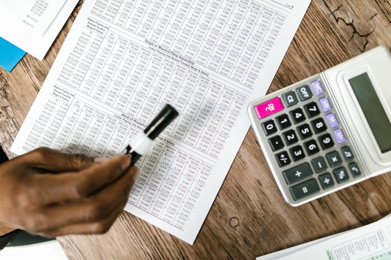 The Art of Drawing Readers In: Your attractive post title goes here Close-up of tax documents and calculator on wooden table, highlighting financial analysis.